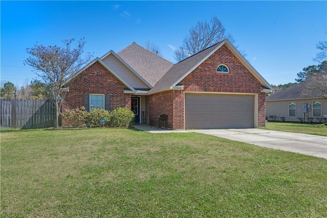 view of front of property featuring a front yard, brick siding, fence, and driveway