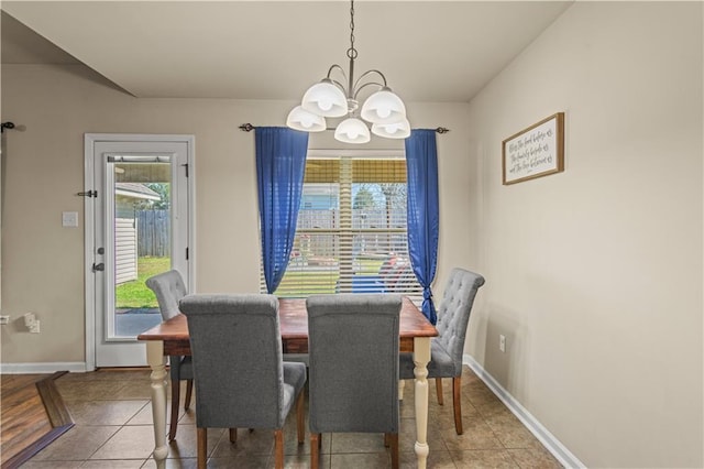 tiled dining area featuring baseboards and a notable chandelier