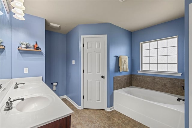 bathroom featuring tile patterned flooring, a garden tub, a sink, and double vanity