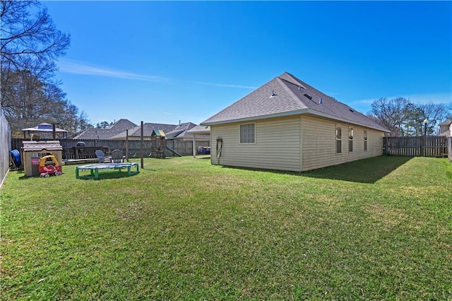 view of yard with a trampoline and a fenced backyard