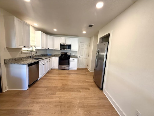 kitchen with white cabinetry, visible vents, appliances with stainless steel finishes, and a sink