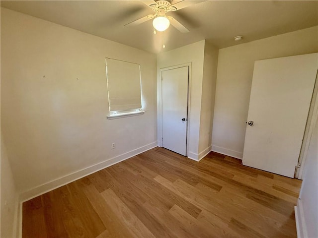 unfurnished bedroom featuring a ceiling fan, baseboards, and wood finished floors