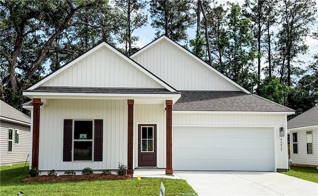 modern farmhouse style home featuring roof with shingles, an attached garage, a front lawn, and driveway