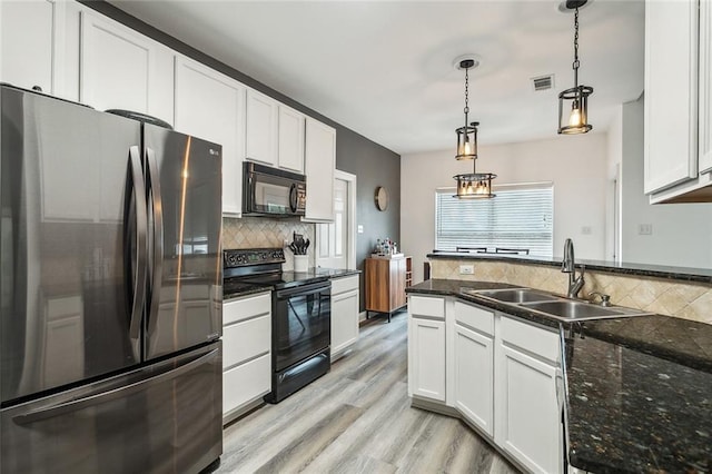 kitchen with decorative backsplash, white cabinets, a sink, and black appliances