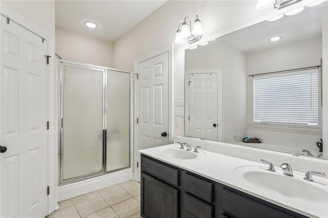 full bathroom featuring a stall shower, tile patterned flooring, and a sink