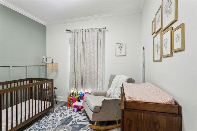 bedroom with a crib, crown molding, and wood finished floors