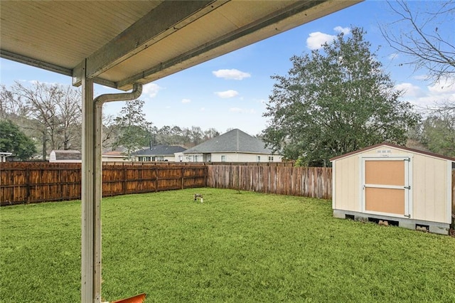 view of yard featuring a fenced backyard, a storage unit, and an outbuilding