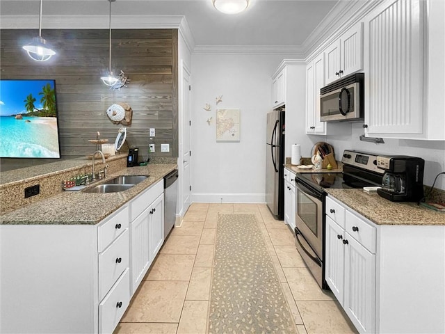 kitchen with appliances with stainless steel finishes, ornamental molding, white cabinets, a sink, and light stone countertops