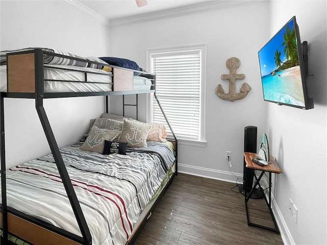 bedroom featuring baseboards, wood finished floors, and crown molding