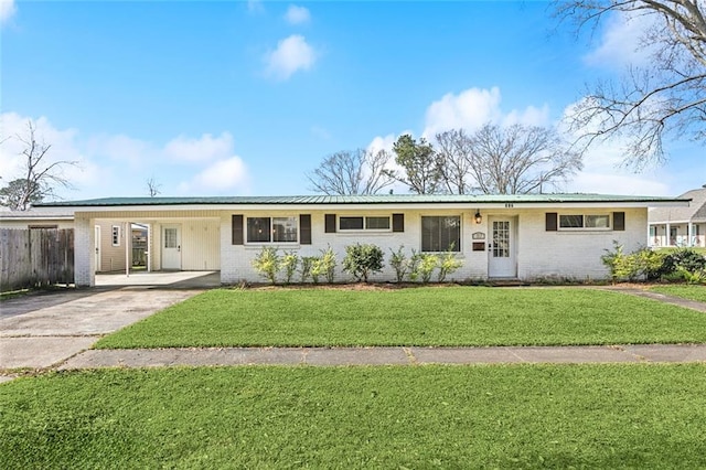 ranch-style home featuring a front yard, brick siding, driveway, and an attached carport