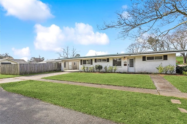 ranch-style house featuring brick siding, fence, and a front lawn