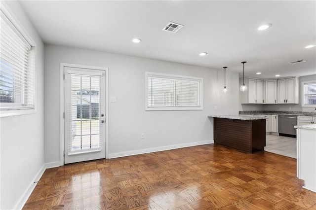 kitchen with dishwasher, a peninsula, visible vents, and baseboards