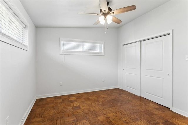 unfurnished bedroom featuring multiple windows, a closet, a ceiling fan, and baseboards