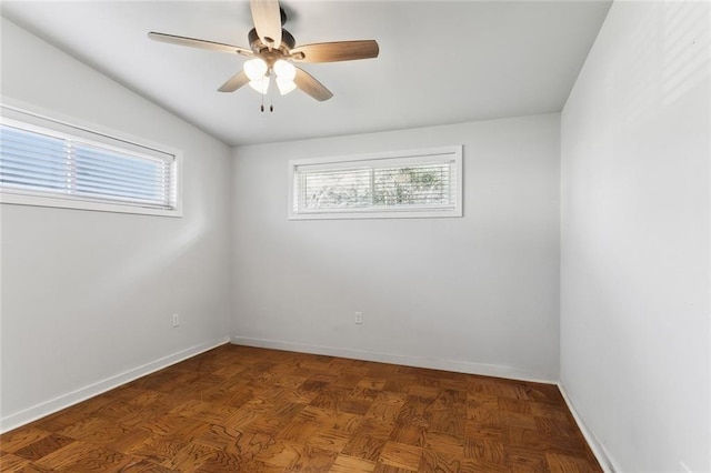 empty room with ceiling fan, plenty of natural light, and baseboards