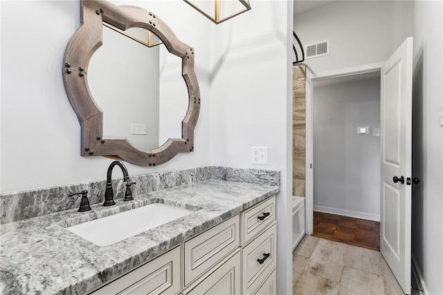 bathroom featuring baseboards, visible vents, and vanity