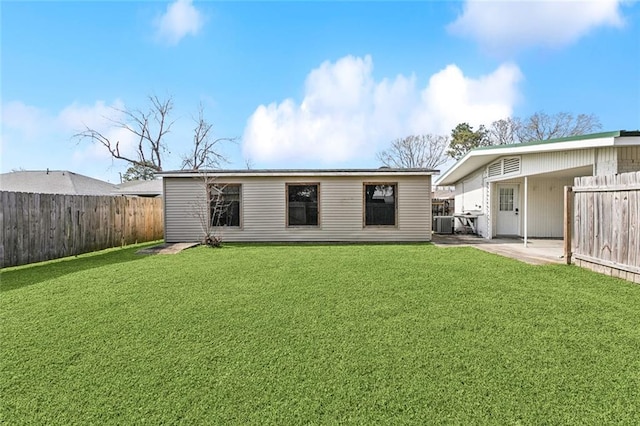 back of house featuring central air condition unit, a patio area, a fenced backyard, and a lawn