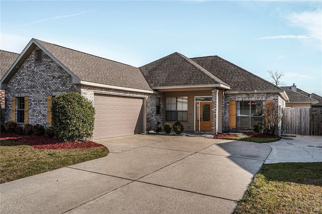 view of front of house with an attached garage, a shingled roof, concrete driveway, and brick siding