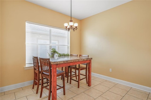 dining area featuring light tile patterned flooring, a notable chandelier, and baseboards