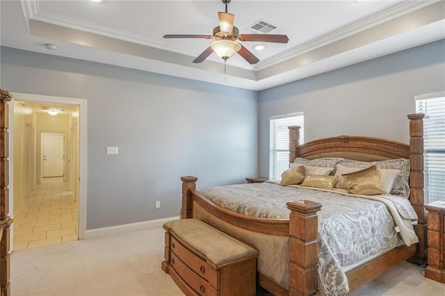 bedroom featuring a tray ceiling, visible vents, and crown molding