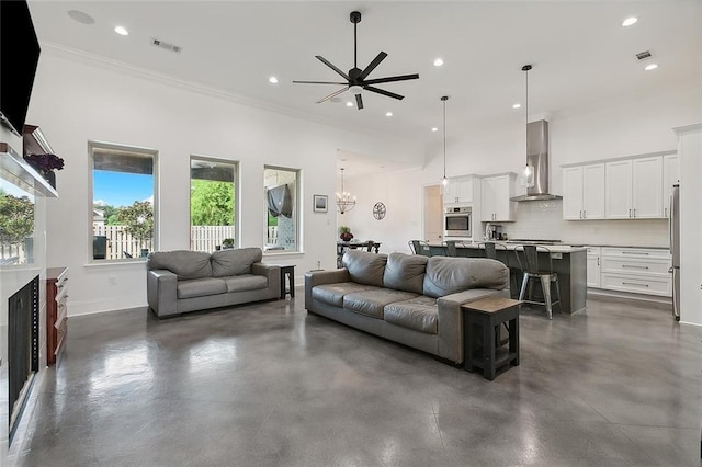 living room featuring visible vents, a high ceiling, concrete floors, crown molding, and baseboards