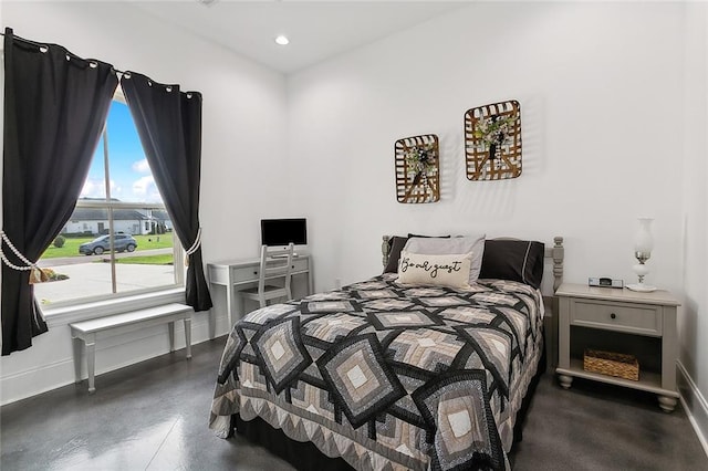 bedroom featuring concrete floors, baseboards, and recessed lighting