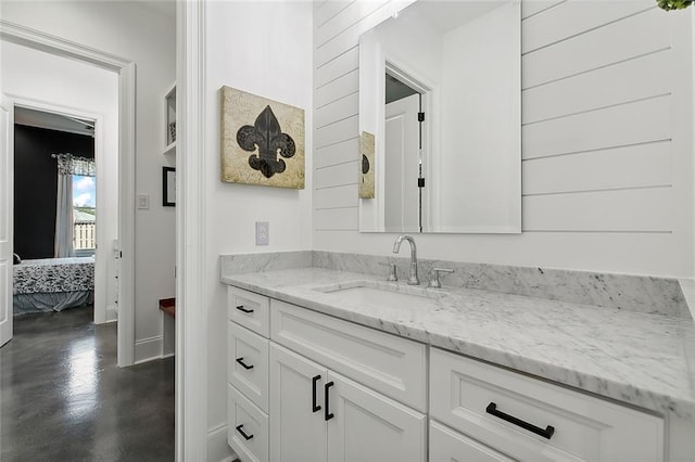 ensuite bathroom featuring vanity and finished concrete floors