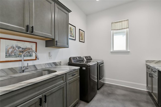 washroom with separate washer and dryer, cabinet space, and baseboards