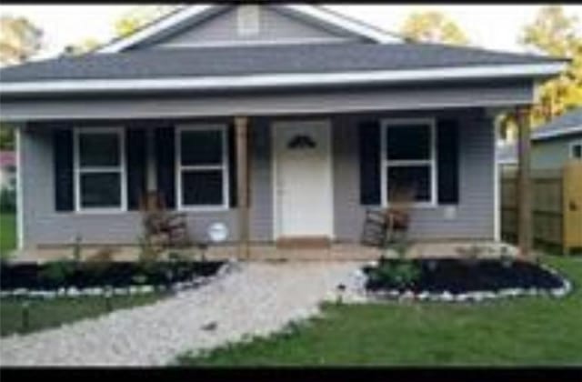 view of front of house with a porch and a front yard