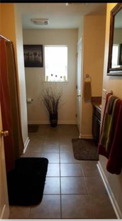 bathroom with vanity, baseboards, and tile patterned floors