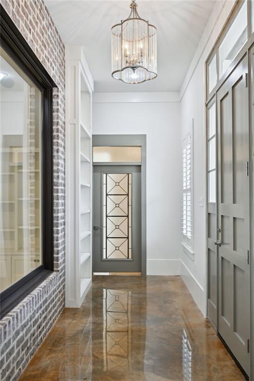 foyer featuring baseboards and an inviting chandelier