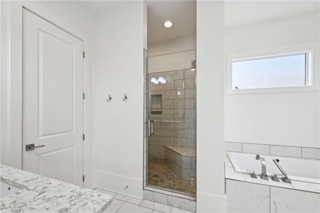 bathroom with a stall shower and a garden tub