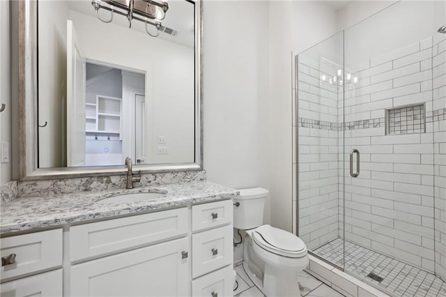 bathroom featuring toilet, a notable chandelier, visible vents, vanity, and a shower stall