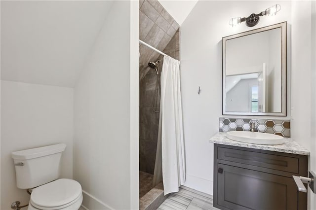 full bath with toilet, tasteful backsplash, vaulted ceiling, and a tile shower