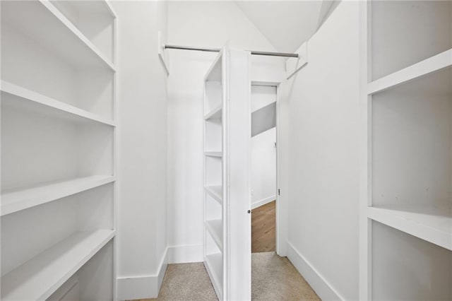 spacious closet with carpet and vaulted ceiling