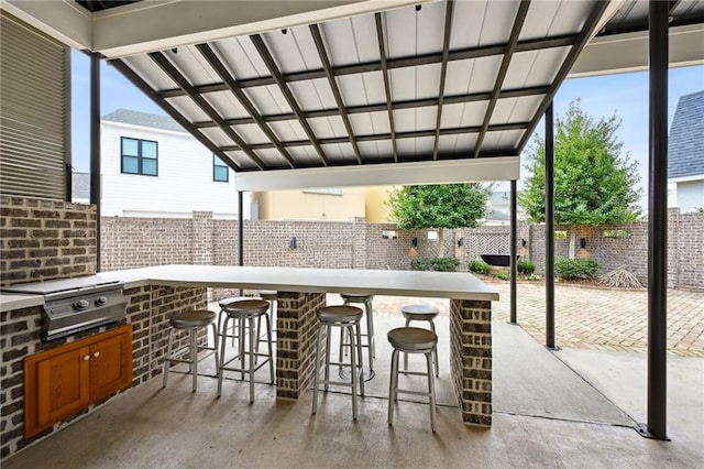 view of patio with outdoor wet bar, fence, grilling area, and area for grilling