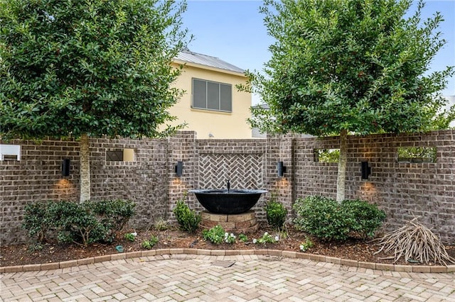 exterior space featuring metal roof, brick siding, fence, and stucco siding