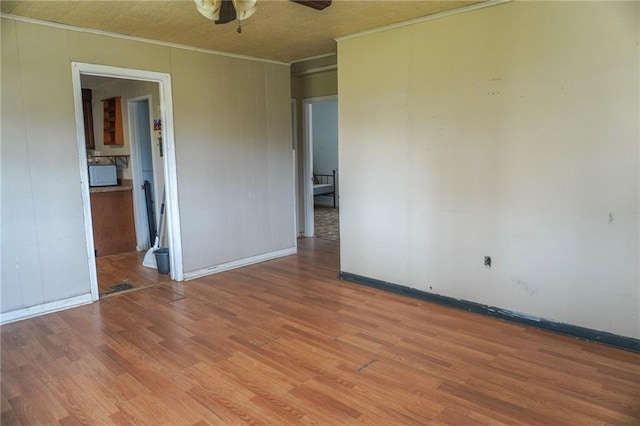 spare room with a ceiling fan, light wood-type flooring, and crown molding