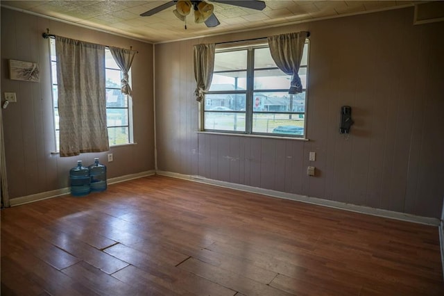 empty room with hardwood / wood-style flooring, ceiling fan, and baseboards