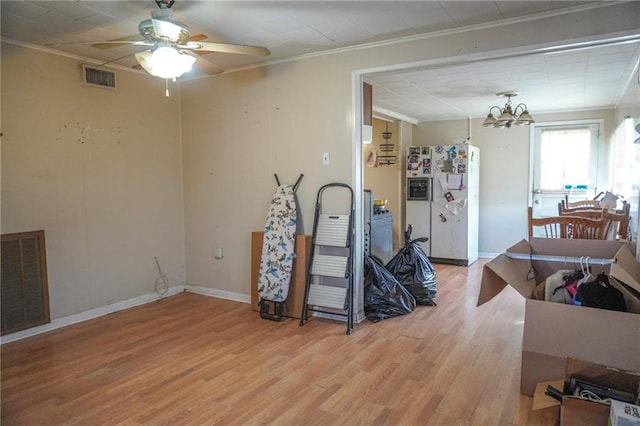 interior space featuring light wood finished floors, visible vents, and crown molding