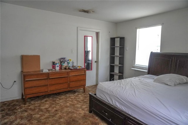 bedroom featuring dark colored carpet and visible vents