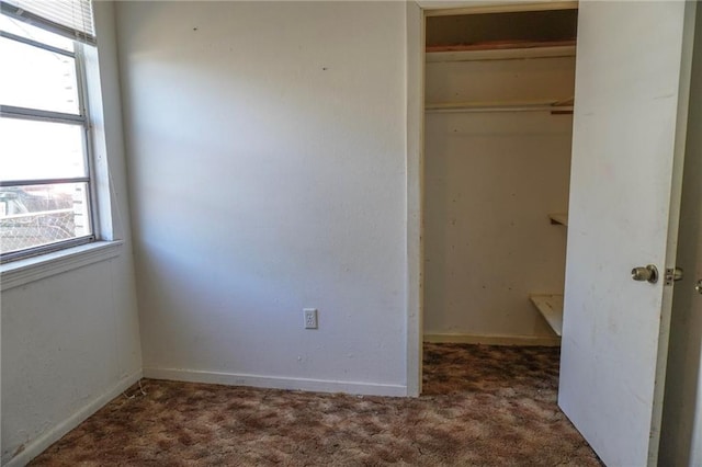 unfurnished bedroom featuring carpet, baseboards, and a closet