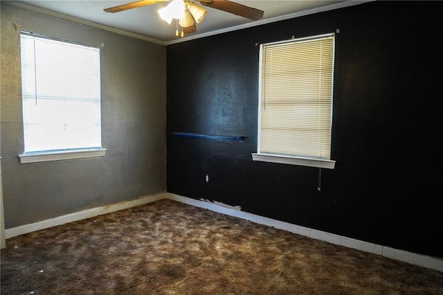 carpeted spare room with a ceiling fan, baseboards, and crown molding