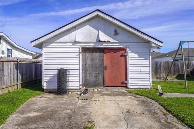 view of outdoor structure with fence and an outbuilding