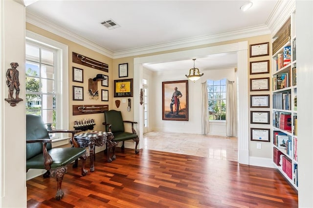 sitting room with ornamental molding, baseboards, visible vents, and wood finished floors