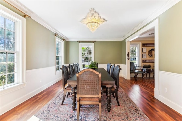 dining space with an inviting chandelier, plenty of natural light, wood finished floors, and ornamental molding