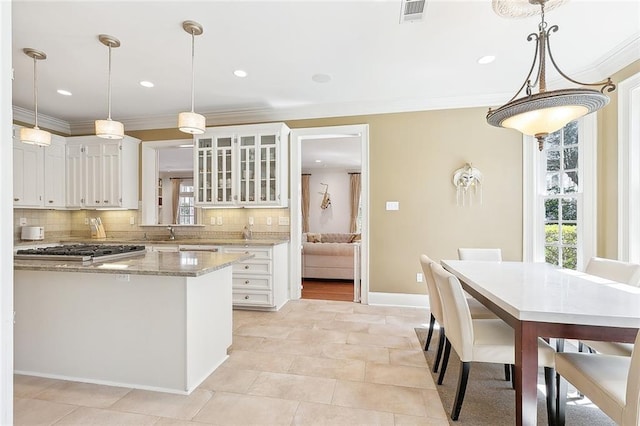 kitchen featuring ornamental molding, stainless steel gas stovetop, decorative backsplash, and visible vents