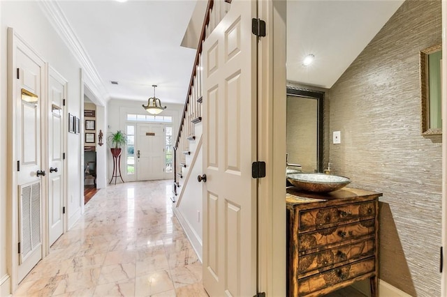 corridor with a sink, crown molding, baseboards, marble finish floor, and stairs