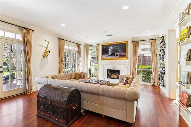 living room featuring a premium fireplace, ornamental molding, plenty of natural light, and visible vents