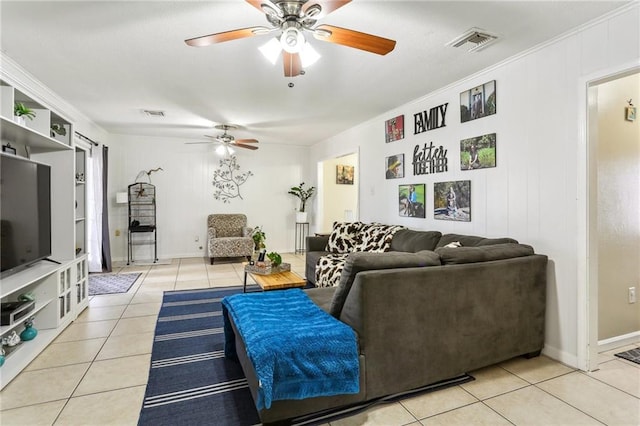 living area featuring light tile patterned floors, ceiling fan, visible vents, and crown molding