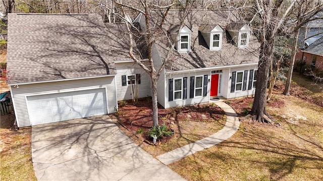 cape cod-style house featuring a garage, driveway, and roof with shingles